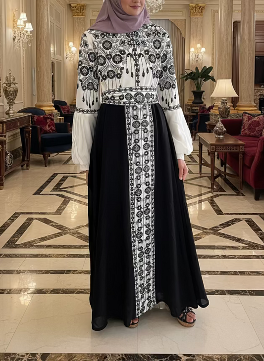 A person wearing a traditional embroidered dress with black and white patterns.